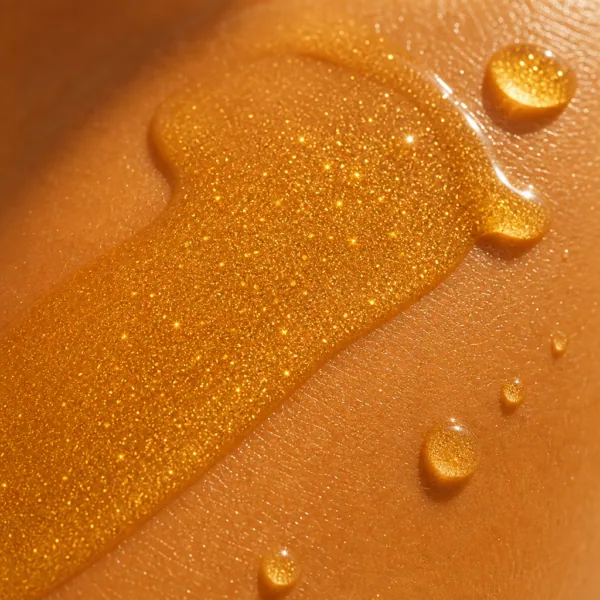 Texture de l’huile de bronzage, paillettes dorées sur la peau